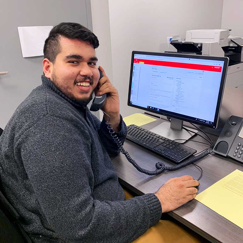 Hamid, a Fellowship Program member, on the phone and smiling towards the camera.