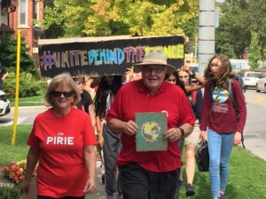 Pirie and friends holding signs in red march with students for protecting the climate.